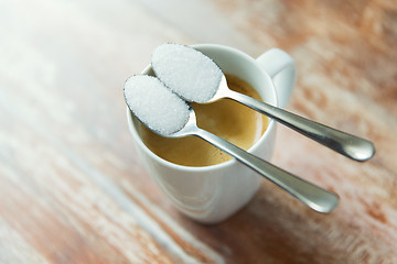 Image showing close up of white sugar on teaspoon and coffee cup