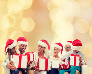 Image showing happy family in santa helper hats with gift boxes