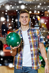 Image showing happy young man holding ball in bowling club