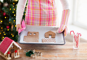 Image showing closeup of woman with gingerbread house on pan