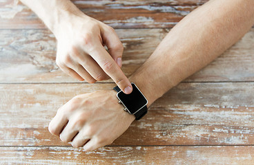 Image showing close up of male hands setting smart watch