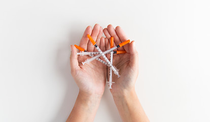 Image showing close up of woman hands holding syringes