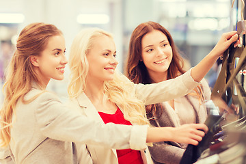Image showing happy young women choosing clothes in mall