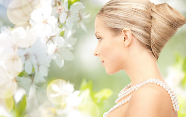 Image showing woman with pearl necklace over cherry blossom