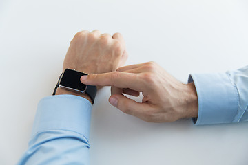 Image showing close up of male hands setting smart watch