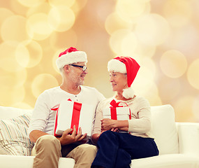 Image showing happy senior couple in santa hats with gift boxes