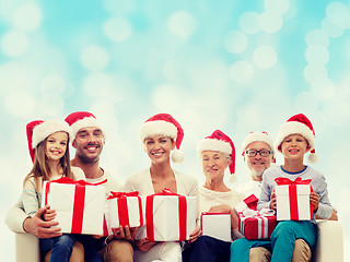 Image showing happy family in santa helper hats with gift boxes