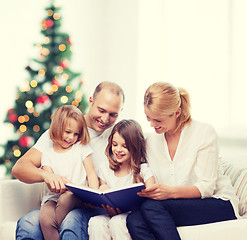 Image showing happy family with book at home