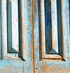 Image showing dirty stripped paint in the blue wood door and rusty nail