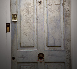 Image showing handle in london antique brown door  rusty  brass nail and light