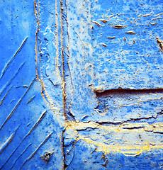 Image showing dirty stripped paint in the blue wood door and rusty nail