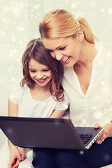 Image showing smiling mother and little girl with laptop at home