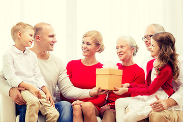 Image showing smiling family with gift at home