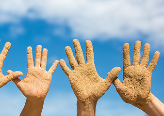 Image showing Woman and Man Shows his Open Hands Covered with Beach Sand