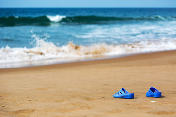 Image showing Women\'s Blue Slippers on a Sandy Ocean Beach