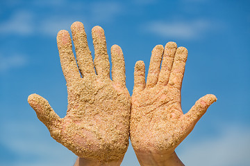 Image showing Woman and Man Shows his Open Hands Covered with Beach Sand