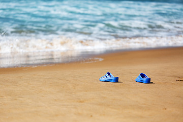 Image showing Women\'s Blue Slippers on a Sandy Ocean Beach