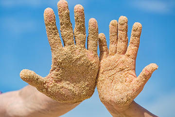 Image showing Woman and Man Shows his Open Hands Covered with Beach Sand