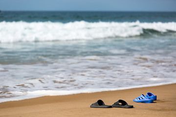 Image showing Women\'s and Men\'s Slippers on a Sandy Ocean Beach