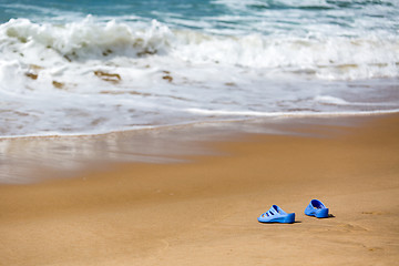 Image showing Women\'s Blue Slippers on a Sandy Ocean Beach