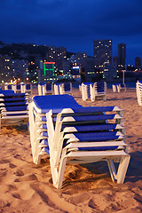 Image showing Empty beach with sunbeds by night