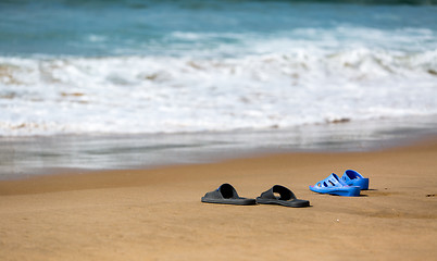 Image showing Women\'s and Men\'s Slippers on a Sandy Ocean Beach