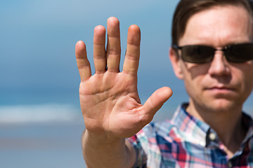 Image showing Man in Sunglasses Showing Stop Sign with his Hand