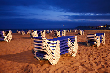 Image showing Empty beach with sunbeds by night