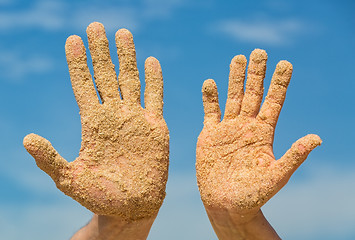 Image showing Woman and Man Shows his Open Hands Covered with Beach Sand