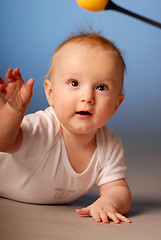 Image showing Little boy trying to touch a toy