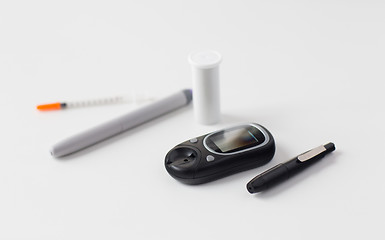 Image showing close up of glucometer, insulin pen and syringe