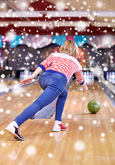 Image showing happy young woman throwing ball in bowling club