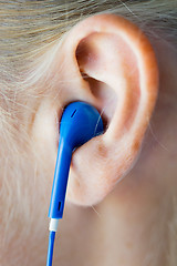 Image showing close up of woman in earphones at home