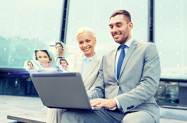 Image showing smiling businesspeople with laptop outdoors