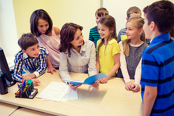 Image showing group of school kids with teacher in classroom