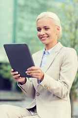 Image showing smiling businesswoman with tablet pc outdoors