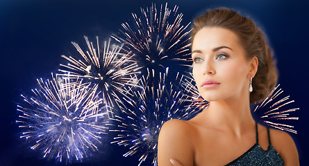 Image showing beautiful woman wearing earrings over firework