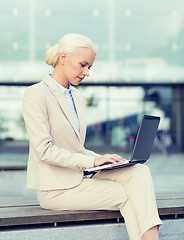 Image showing businesswoman working with laptop outdoors