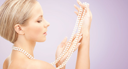 Image showing beautiful woman with pearl necklace over violet