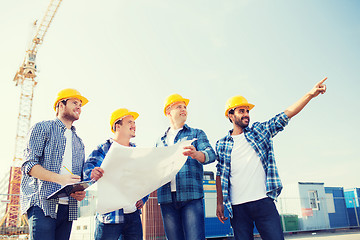 Image showing group of builders with tablet pc and blueprint