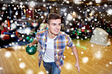 Image showing happy young man throwing ball in bowling club