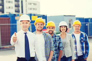 Image showing group of smiling builders in hardhats outdoors