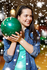 Image showing happy young woman holding ball in bowling club