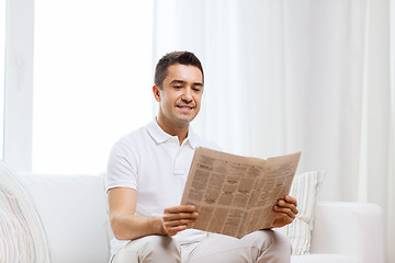 Image showing happy man reading newspaper at home