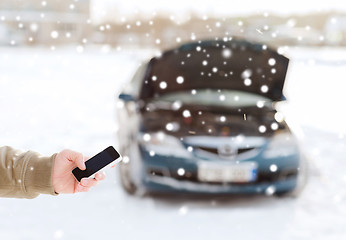 Image showing closeup of man with broken car and smartphone