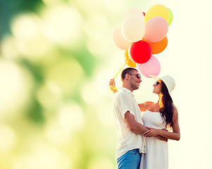 Image showing smiling couple with air balloons outdoors