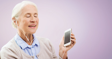 Image showing senior woman with smartphone and earphones