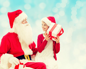 Image showing smiling little girl with santa claus and gifts