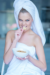 Image showing Woman in Bath Towel Eating Snacks from Bowl