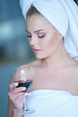 Image showing Woman in Bath Towel Looking Down at Glass of Wine
